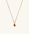 Sia Birthstone Pendant Necklace featuring a gold chain with a red gemstone pendant, perfect for adding a personal touch to any outfit.