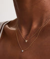 Person wearing a Mini Heart Pavé Diamond Necklace, showcasing a close-up of the heart-shaped pendant on a delicate chain.